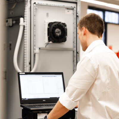 Fachkraft testet Steuerungssysteme für elektrische Anlagen – Kreutzpointner.