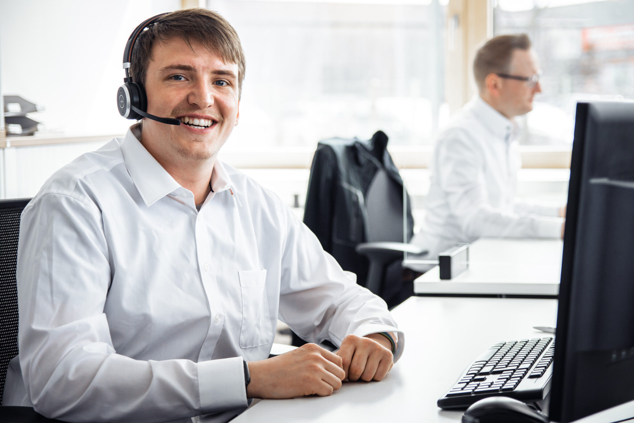 Mitarbeiter im IT-Support mit Headset für sichere Informationstechnik – Kreutzpointner.