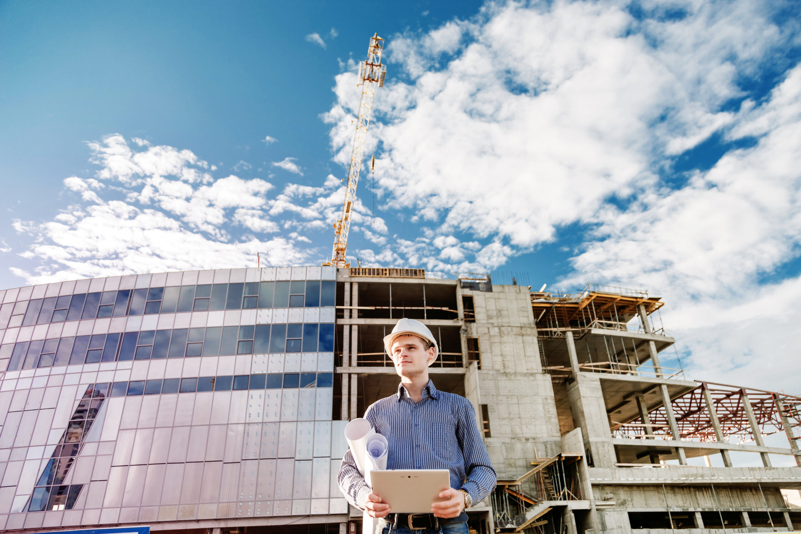 Construction manager controlling building site with plan