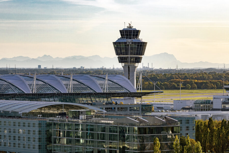 Flughafen und Tower bei Sonnenuntergang und Weitblick auf die Berge im Hintergrund.