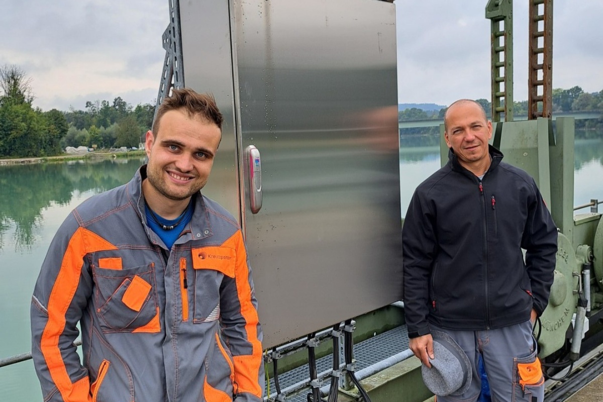 Zwei Arbeiter stehen vor einer technischen Anlage