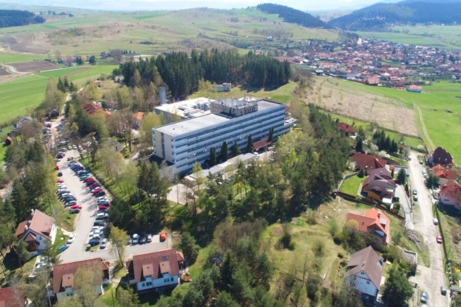 Luftaufnahme eines Krankenhauses mit grüner Umgebung und angrenzenden Häusern