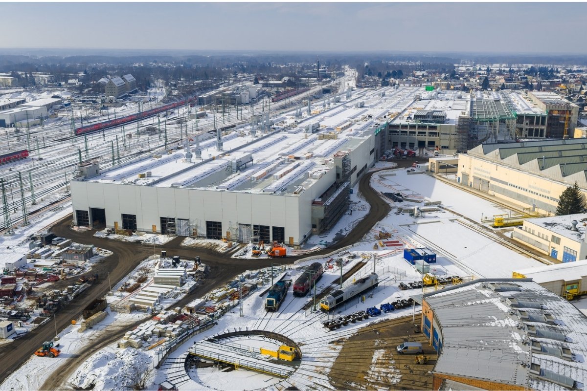 Luftaufnahme einer großen Halle in einer winterlichen Umgebung.